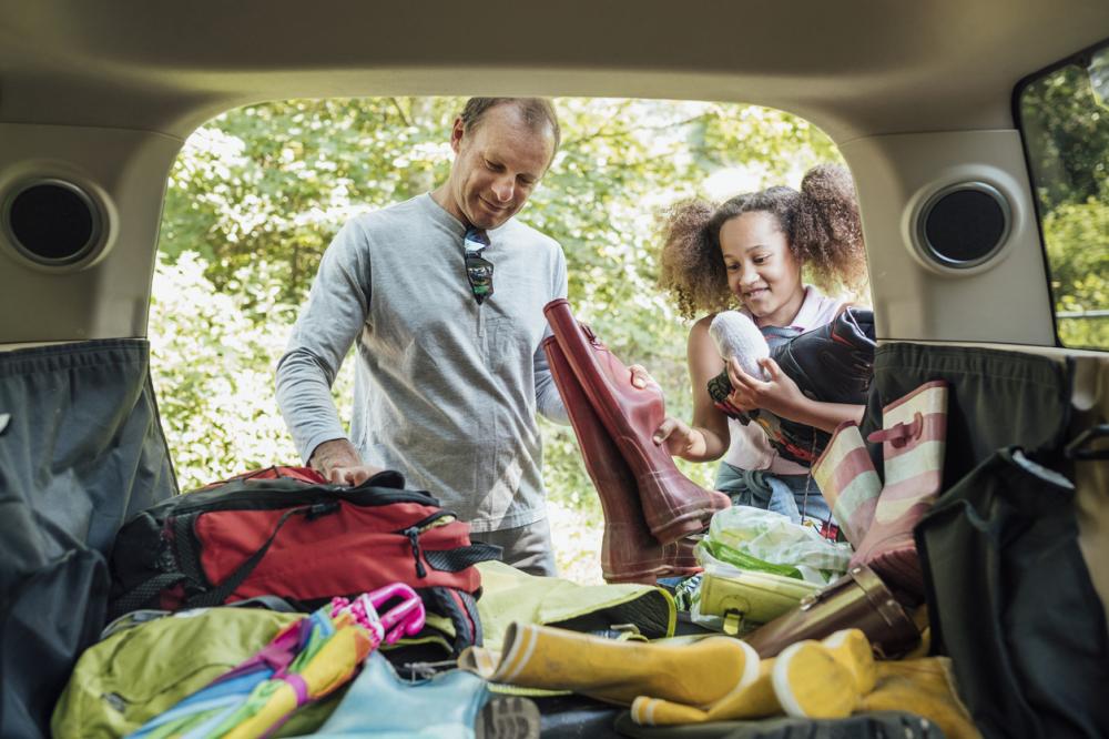 Image of Dad and daughter packing the car for a camping trip.